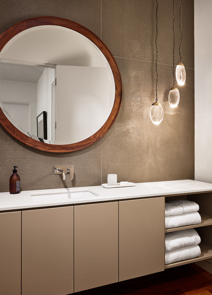 Inspiration for a small modern bathroom in Austin with flat-panel cabinets, beige cabinets, beige tile, porcelain tile, beige walls, medium hardwood floors, an undermount sink and engineered quartz benchtops.