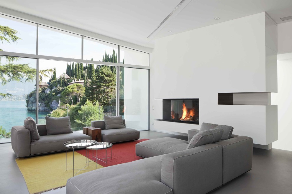 This is an example of a large contemporary formal open concept living room in Munich with white walls, concrete floors and no tv.