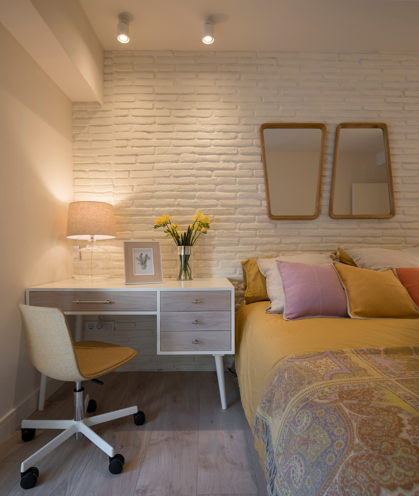 Mid-sized transitional kids' room in Bilbao with white walls and laminate floors for girls.