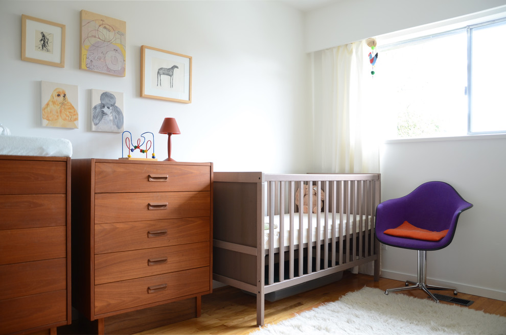 Midcentury gender-neutral nursery in Vancouver with white walls and light hardwood floors.