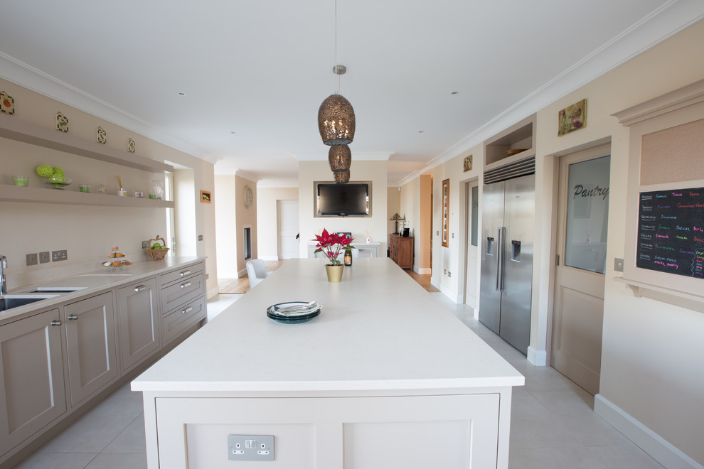 This is an example of a large contemporary kitchen in Dublin with an undermount sink, shaker cabinets, quartz benchtops, stainless steel appliances and with island.