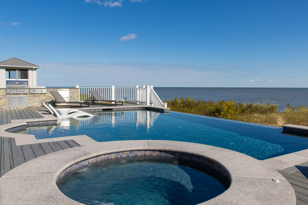 Inspiration for a mid-sized contemporary backyard custom-shaped infinity hot tub remodel with decking
