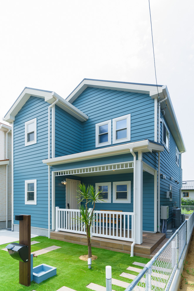 Beach style two-storey blue house exterior in Other with mixed siding, a clipped gable roof and a metal roof.