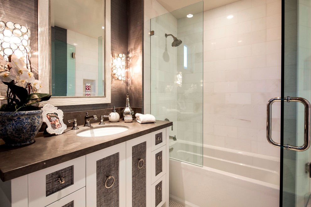 Mid-sized beach style 3/4 bathroom in Orange County with furniture-like cabinets, white cabinets, a drop-in tub, an alcove shower, stone tile, white walls, marble floors, an undermount sink and limestone benchtops.