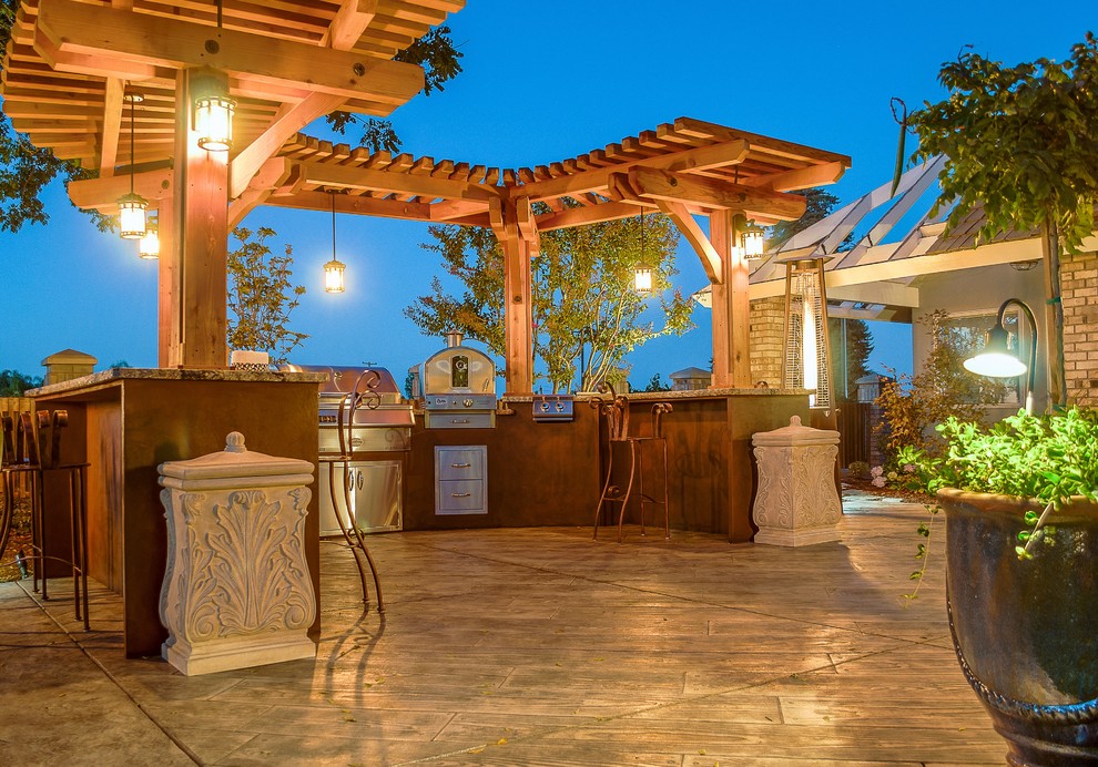 Design ideas for a large country backyard patio in Other with an outdoor kitchen, stamped concrete and a pergola.
