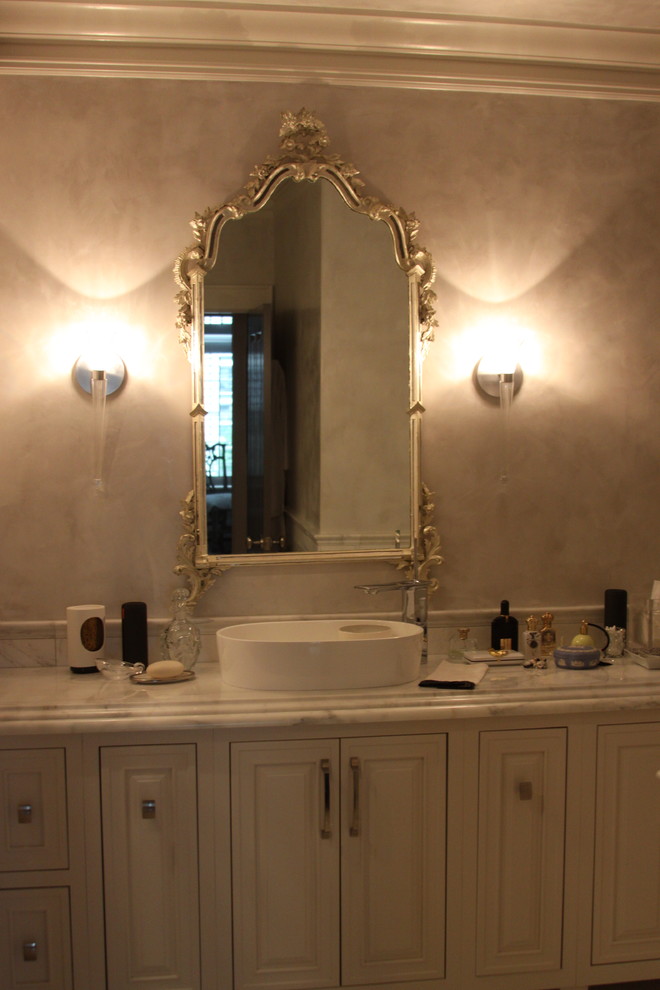 Mid-sized transitional master multicolored tile and stone tile marble floor freestanding bathtub photo in Atlanta with a vessel sink, beaded inset cabinets, beige cabinets, marble countertops, a one-piece toilet and gray walls