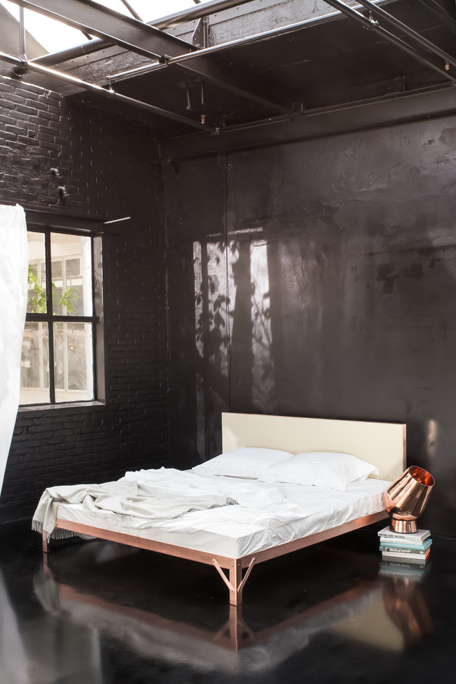 Large industrial master bedroom in Essen with black walls, black floor, laminate floors and no fireplace.