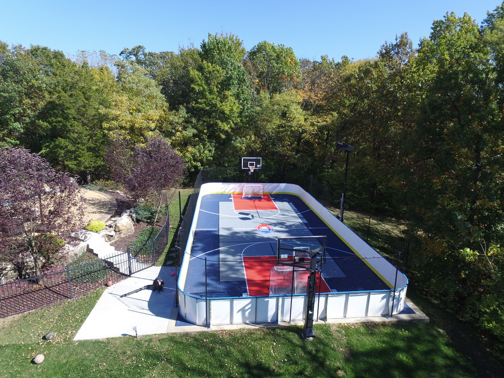 This is an example of a large traditional backyard partial sun outdoor sport court for summer in St Louis with with outdoor playset and concrete pavers.