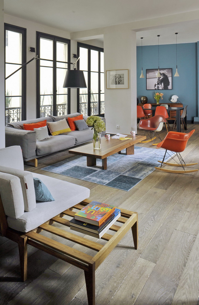 Photo of an eclectic living room in Paris with white walls and light hardwood floors.
