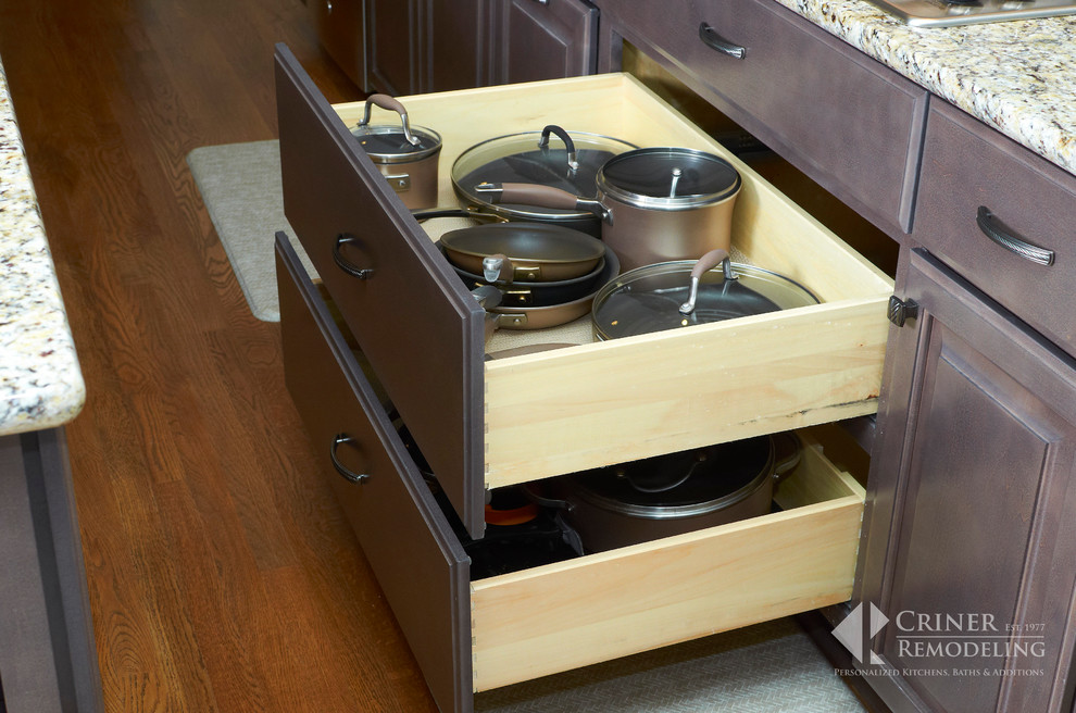 Inspiration for a transitional light wood floor eat-in kitchen remodel with shaker cabinets, dark wood cabinets, granite countertops, beige backsplash, glass tile backsplash, stainless steel appliances and an island