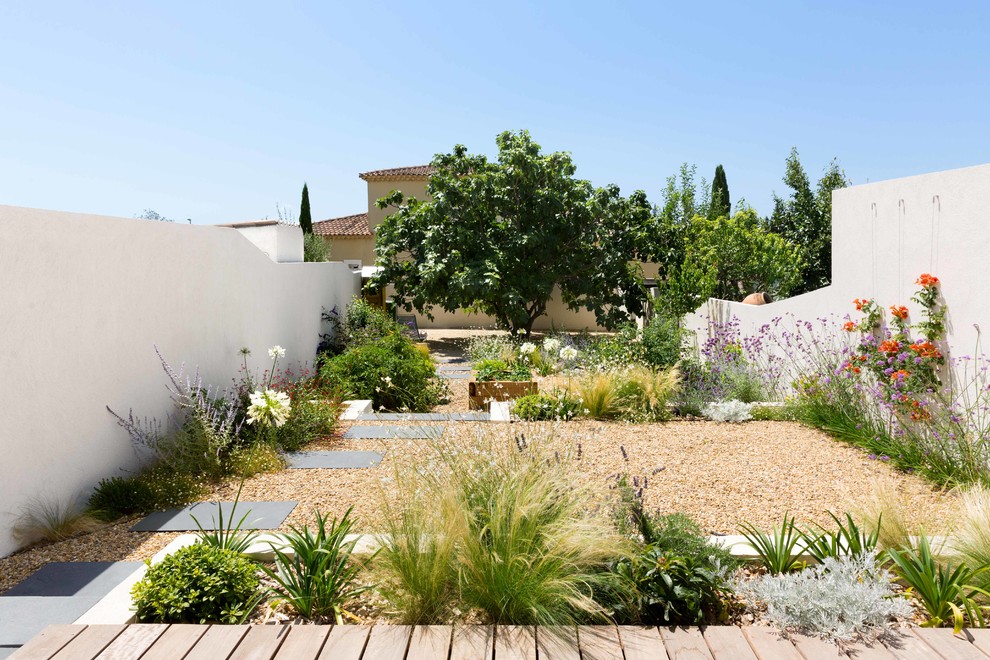 Contemporary backyard formal garden in Other with a garden path and gravel.