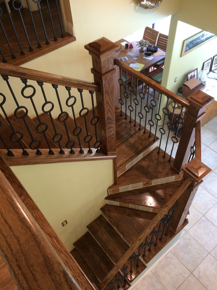 This is an example of a transitional wood u-shaped staircase in Tampa with tile risers and mixed railing.