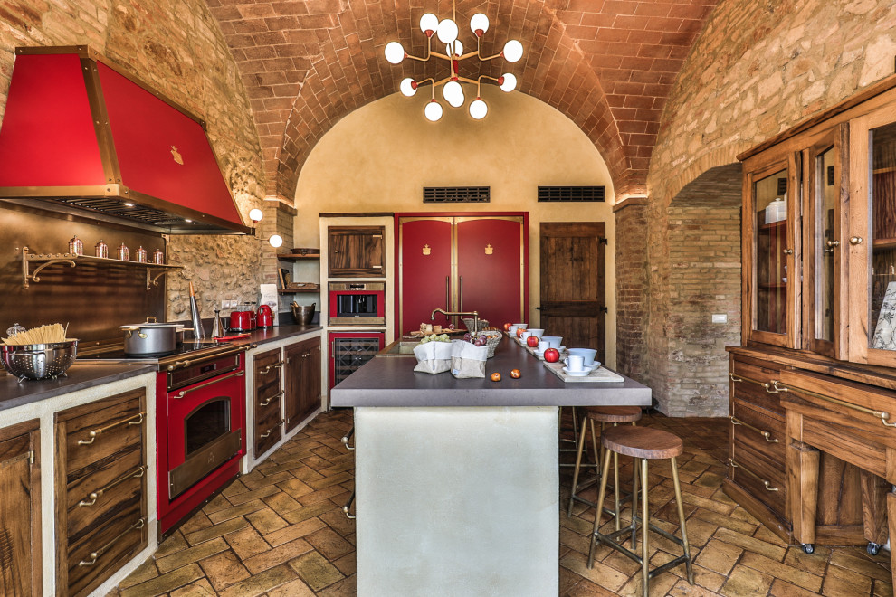 Inspiration for an expansive mediterranean l-shaped separate kitchen in Florence with a farmhouse sink, glass-front cabinets, medium wood cabinets, quartzite benchtops, multi-coloured splashback, engineered quartz splashback, panelled appliances, terra-cotta floors, with island, orange floor, multi-coloured benchtop and vaulted.