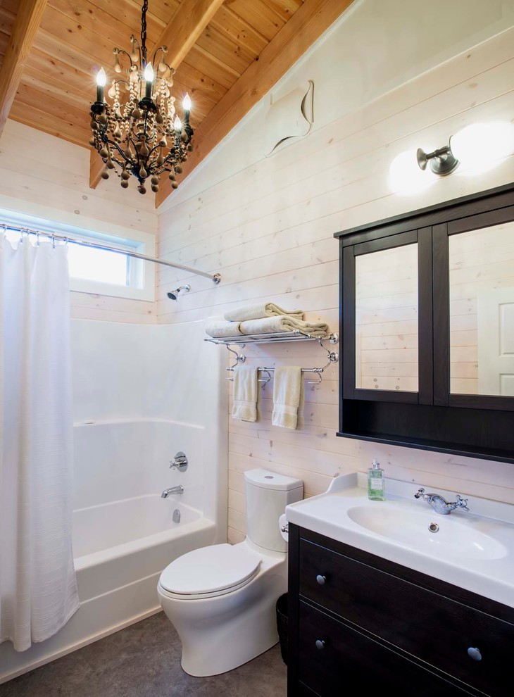 Example of a mid-sized mountain style 3/4 alcove shower design with furniture-like cabinets, black cabinets, a one-piece toilet, white walls and an integrated sink