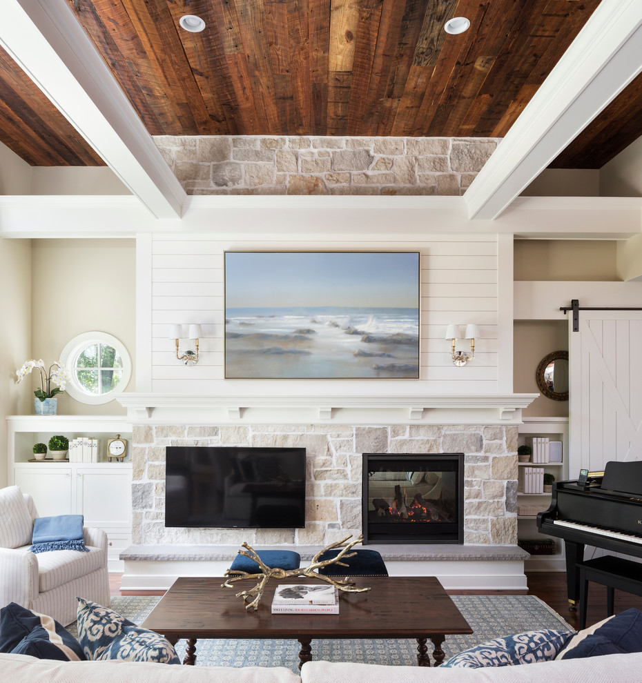 Inspiration for a mid-sized beach style family room in Minneapolis with a two-sided fireplace, a stone fireplace surround, a wall-mounted tv, white walls and dark hardwood floors.