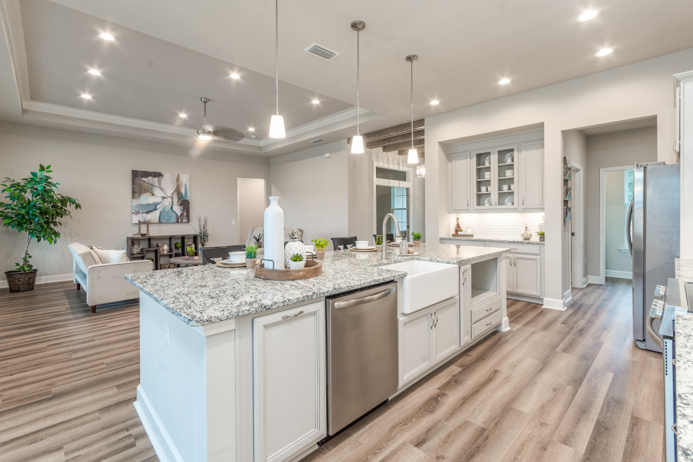 Inspiration for a mid-sized transitional galley vinyl floor and multicolored floor eat-in kitchen remodel with a farmhouse sink, recessed-panel cabinets, granite countertops, white backsplash, subway tile backsplash, stainless steel appliances, an island, multicolored countertops and gray cabinets