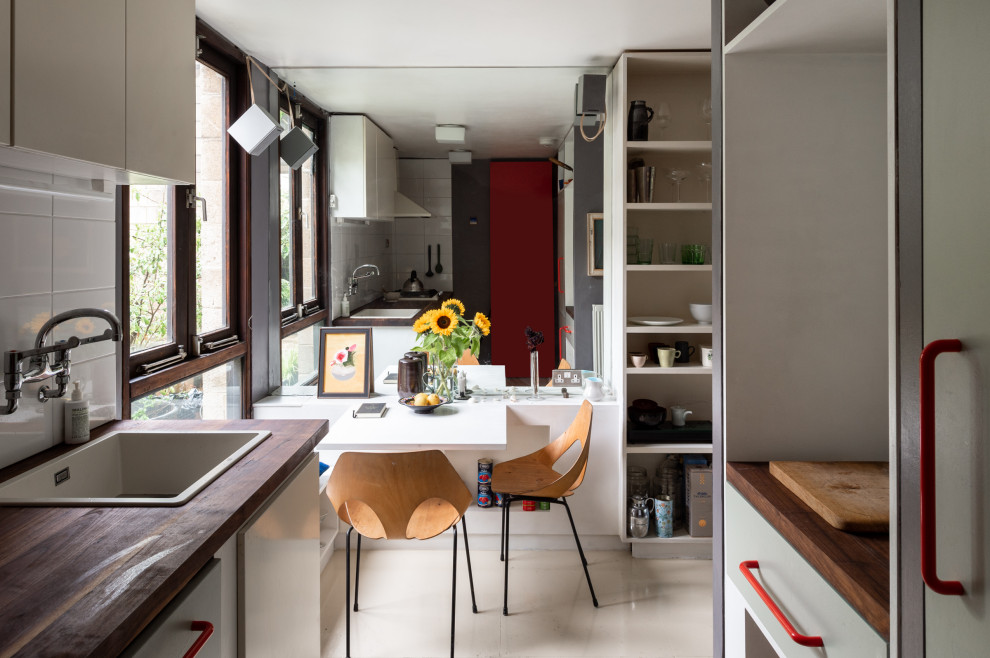 Inspiration for a midcentury kitchen in London with grey cabinets and wood benchtops.