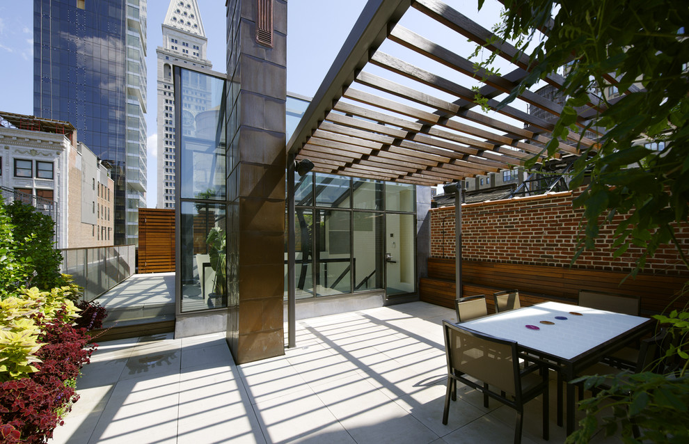 Photo of an expansive contemporary patio in New York with a pergola.