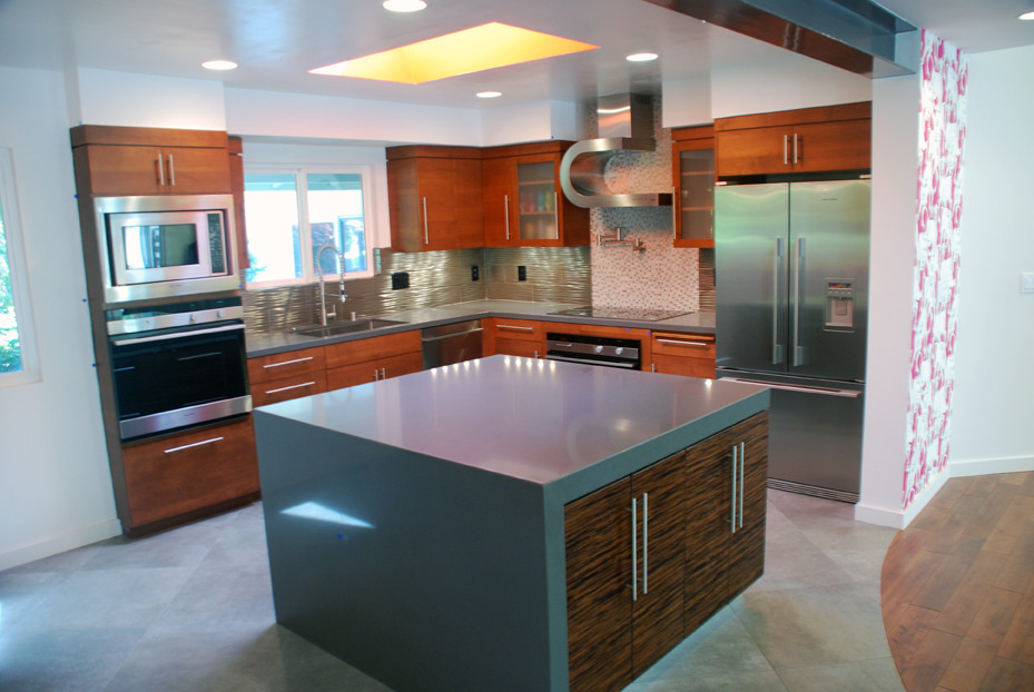 Photo of a mid-sized modern l-shaped eat-in kitchen in San Francisco with an undermount sink, flat-panel cabinets, dark wood cabinets, quartz benchtops, metallic splashback, metal splashback, stainless steel appliances, porcelain floors and with island.