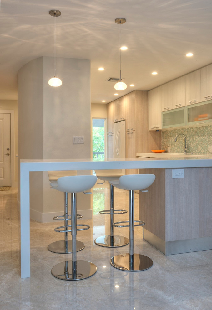 Inspiration for a mid-sized contemporary galley eat-in kitchen in Tampa with an undermount sink, flat-panel cabinets, light wood cabinets, solid surface benchtops, blue splashback, glass tile splashback, white appliances, marble floors and a peninsula.