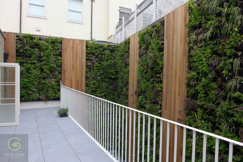 Design ideas for a large contemporary side yard deck in London with a vertical garden and no cover.