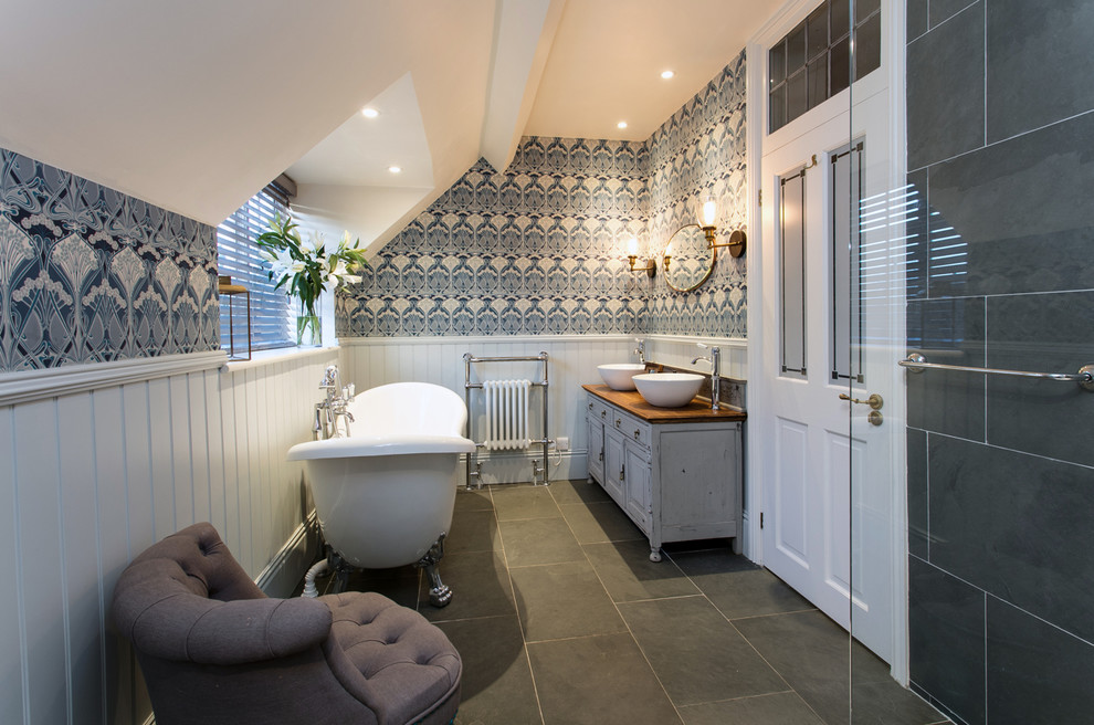 Mid-sized traditional kids bathroom in Surrey with shaker cabinets, grey cabinets, a freestanding tub, an open shower, a two-piece toilet, gray tile, slate, grey walls, slate floors, a console sink, wood benchtops, grey floor, an open shower and brown benchtops.