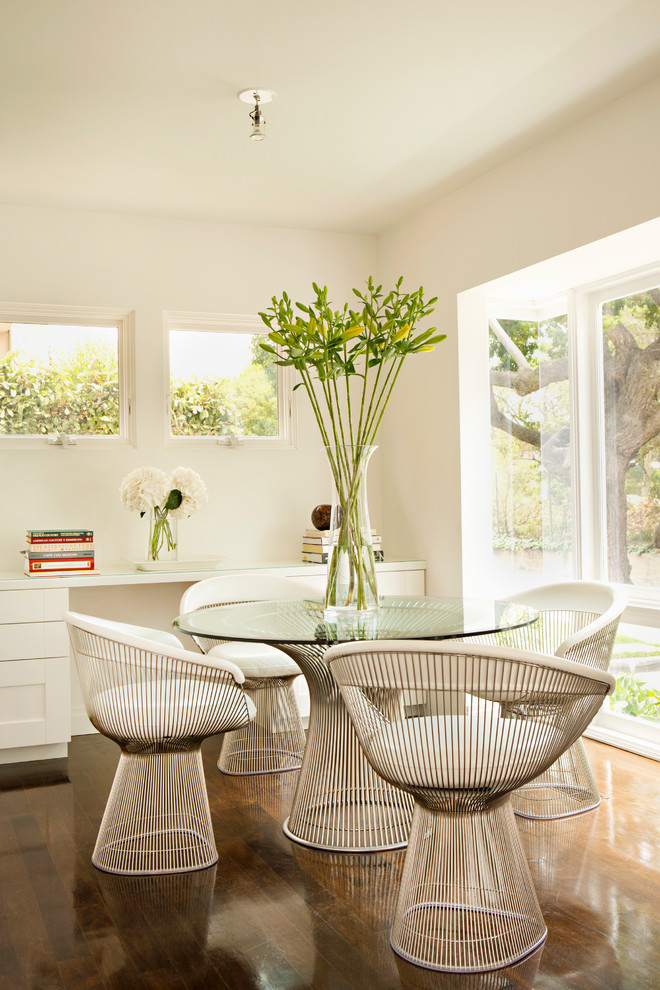 This is an example of a transitional dining room in Los Angeles with white walls and dark hardwood floors.