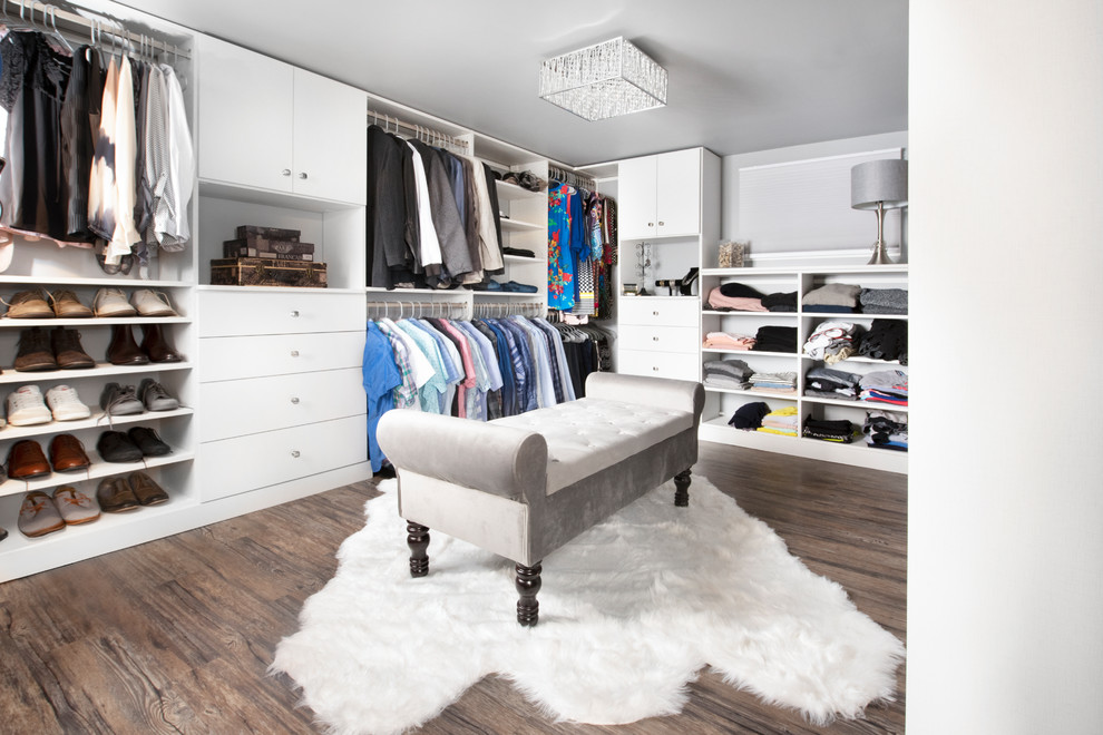 Design ideas for a large transitional gender-neutral walk-in wardrobe in Chicago with flat-panel cabinets, white cabinets, vinyl floors and brown floor.