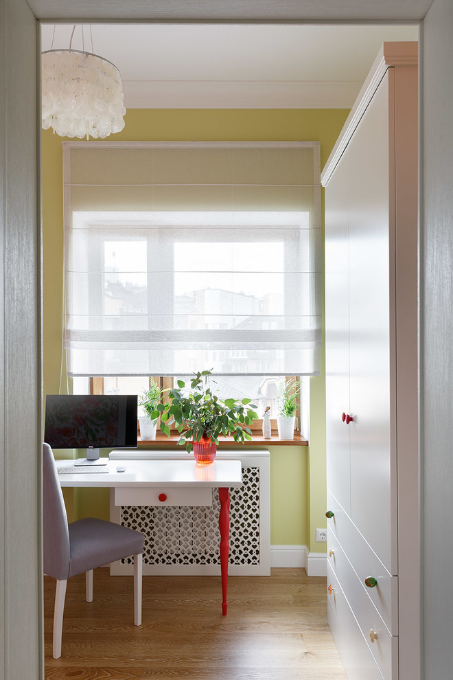 Inspiration for a small transitional study room in Saint Petersburg with green walls, medium hardwood floors, a freestanding desk and brown floor.