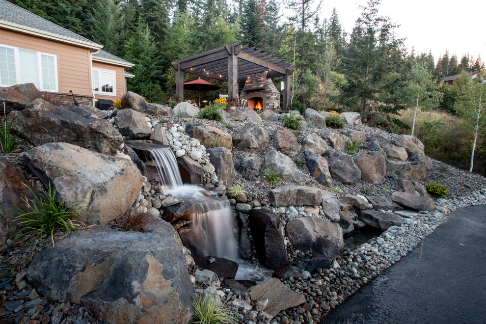 Photo of a mid-sized rustic front yard concrete paver water fountain landscape.