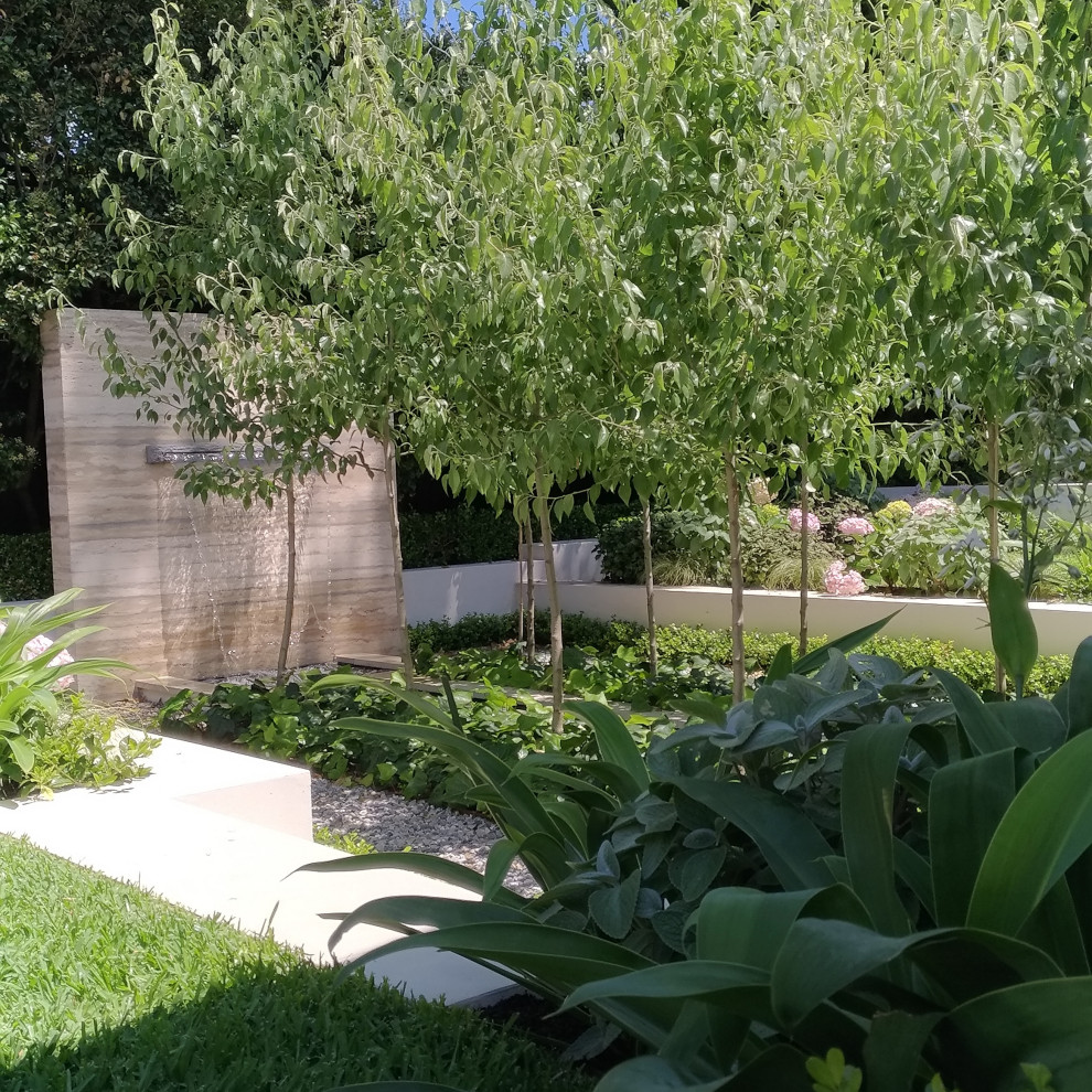 Mid-sized traditional backyard partial sun formal garden in Sydney with with waterfall and natural stone pavers.