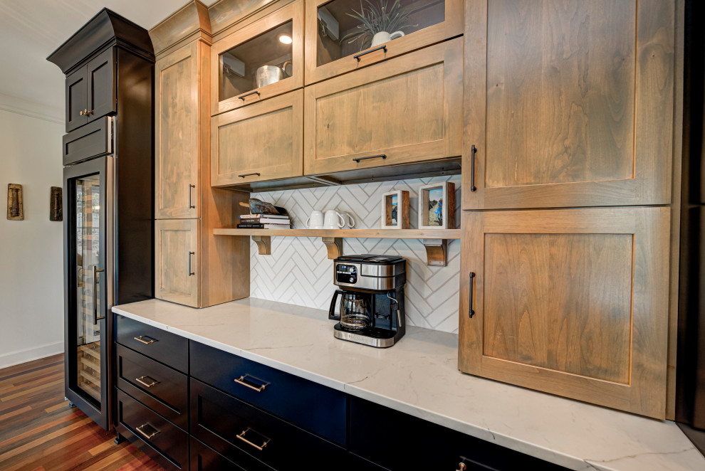 インディアナポリスにある高級な中くらいなコンテンポラリースタイルのおしゃれなキッチン (アンダーカウンターシンク、シェーカースタイル扉のキャビネット、中間色木目調キャビネット、白いキッチンパネル、サブウェイタイルのキッチンパネル、シルバーの調理設備、無垢フローリング、大理石カウンター、白い床、白いキッチンカウンター) の写真
