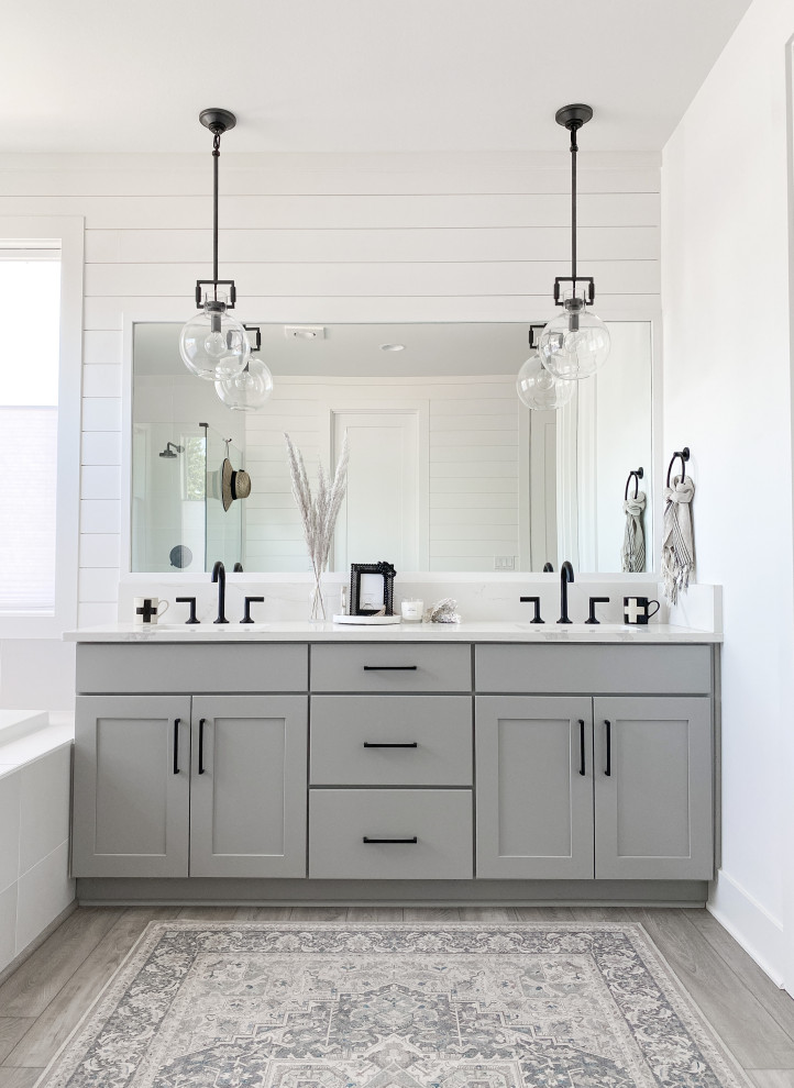 Mid-sized beach style master bathroom in Seattle with shaker cabinets, grey cabinets, white tile, laminate floors, engineered quartz benchtops, grey floor, white benchtops, a shower seat, a double vanity, a built-in vanity and planked wall panelling.
