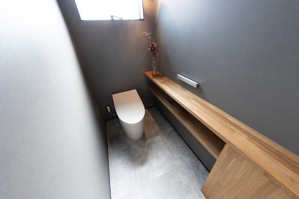 Exemple d'un WC et toilettes moderne avec WC à poser, un mur gris, un sol en vinyl, un sol gris, un plafond en papier peint et du papier peint.