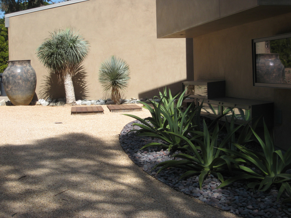 Photo of a mid-sized modern front yard partial sun driveway for spring in Los Angeles with gravel.