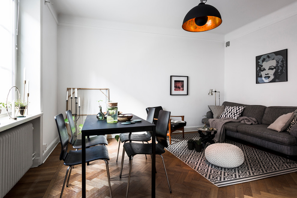 This is an example of a mid-sized scandinavian open plan dining in Stockholm with white walls and dark hardwood floors.