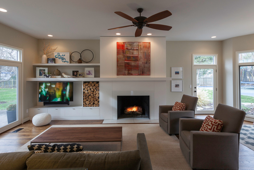 Mid-sized modern open concept living room in Kansas City with white walls, medium hardwood floors, a standard fireplace, a metal fireplace surround and a built-in media wall.