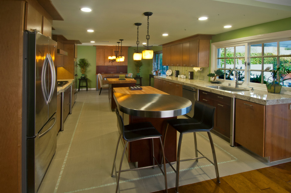 Inspiration for a mid-sized asian galley eat-in kitchen in Orange County with a single-bowl sink, flat-panel cabinets, light wood cabinets, quartzite benchtops, green splashback, glass tile splashback, stainless steel appliances, porcelain floors and multiple islands.