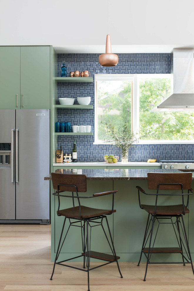 Photo of a transitional kitchen in San Francisco with green cabinets, blue splashback, ceramic splashback, flat-panel cabinets, stainless steel appliances, light hardwood floors, with island and beige floor.