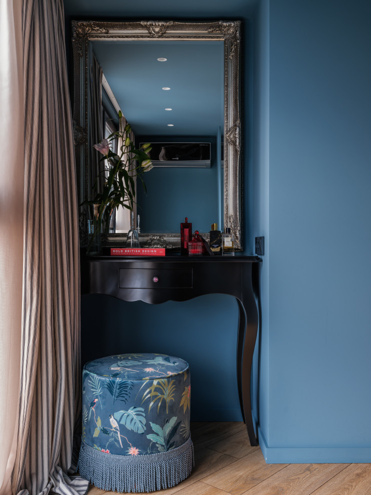 Immagine di una camera matrimoniale bohémian di medie dimensioni con pareti blu, pavimento in legno massello medio, nessun camino, pavimento marrone, travi a vista, carta da parati e angolo studio