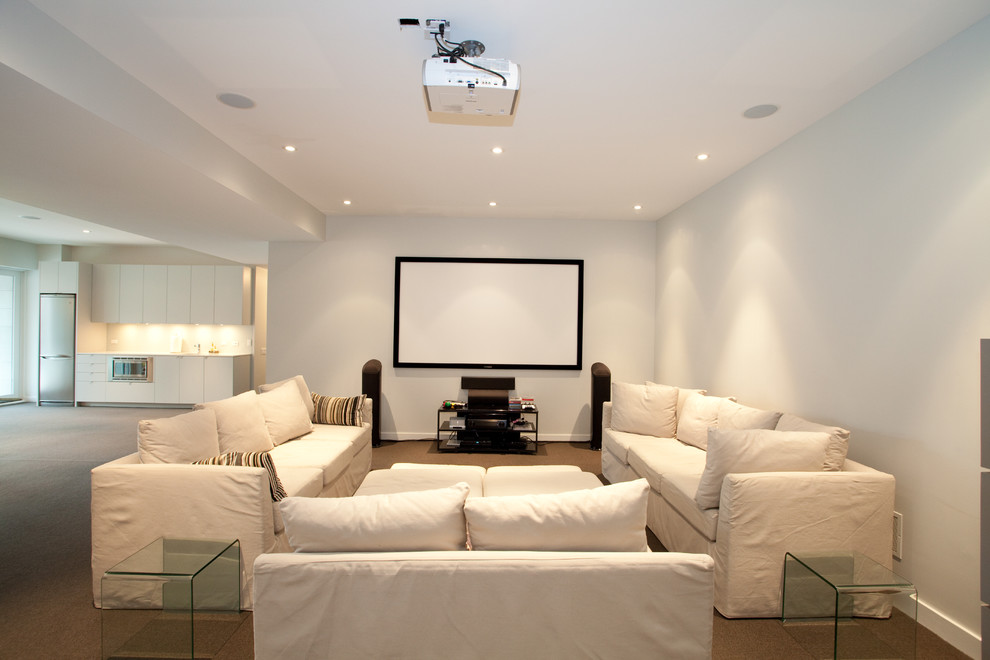 This is an example of a large contemporary enclosed home theatre in Toronto with grey walls, carpet, a projector screen and brown floor.