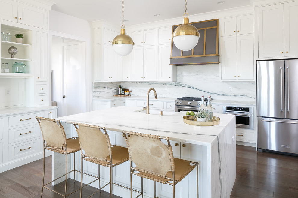 Design ideas for a large transitional l-shaped eat-in kitchen in Louisville with a farmhouse sink, beaded inset cabinets, white cabinets, marble benchtops, white splashback, stone slab splashback, stainless steel appliances, medium hardwood floors and with island.