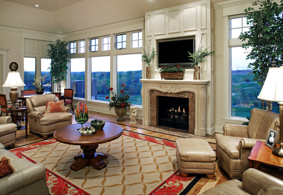 This is an example of a mid-sized formal enclosed living room in Omaha with white walls, light hardwood floors, a standard fireplace, a stone fireplace surround, a built-in media wall and beige floor.