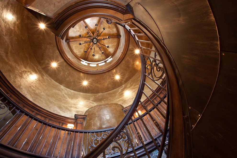 Large mediterranean spiral staircase in Salt Lake City with wood railing.