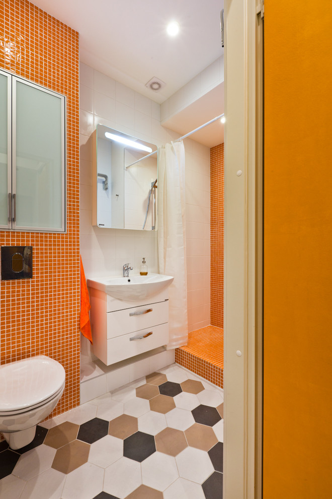 Small contemporary bathroom in Saint Petersburg with a wall-mount toilet, orange tile, mosaic tile, ceramic floors, flat-panel cabinets, white cabinets, an alcove shower and a shower curtain.