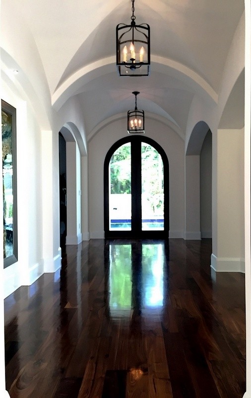Large mediterranean foyer in Tampa with white walls, medium hardwood floors, a single front door, a dark wood front door and brown floor.
