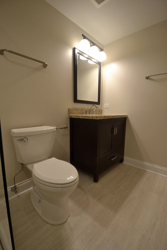 Cette image montre un WC et toilettes minimaliste en bois foncé de taille moyenne avec un placard à porte shaker, WC à poser, un mur beige, un sol en carrelage de céramique, un lavabo posé, un plan de toilette en granite, un sol beige et un plan de toilette multicolore.