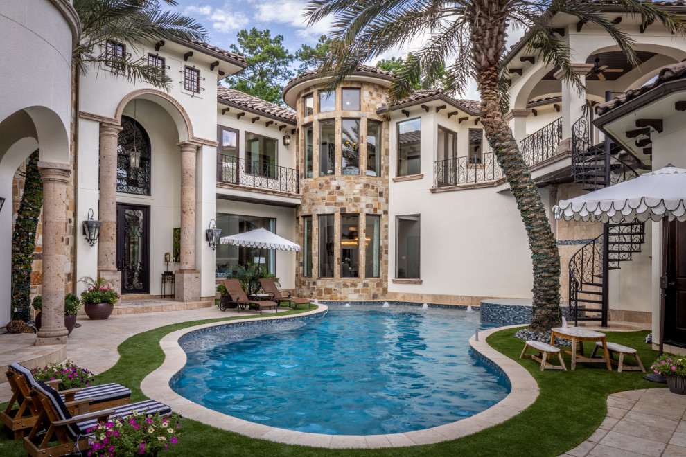 Inspiration for an expansive mediterranean courtyard custom-shaped natural pool in Houston with a hot tub.