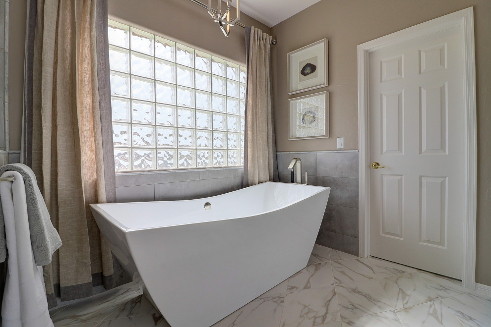 Freestanding bathtub - mid-sized transitional master beige tile and porcelain tile porcelain tile, white floor and double-sink freestanding bathtub idea in Phoenix with raised-panel cabinets, gray cabinets, a two-piece toilet, beige walls, an undermount sink, quartz countertops, a hinged shower door, white countertops and a built-in vanity