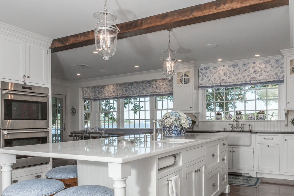 Inspiration for a mid-sized transitional eat-in kitchen in Atlanta with an undermount sink, shaker cabinets, white cabinets, quartzite benchtops, white splashback, subway tile splashback, stainless steel appliances, dark hardwood floors, with island, brown floor and white benchtop.